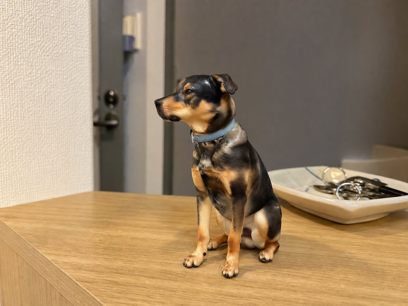 玄関のカウンターに置かれた、黒と茶の犬のフィギュア